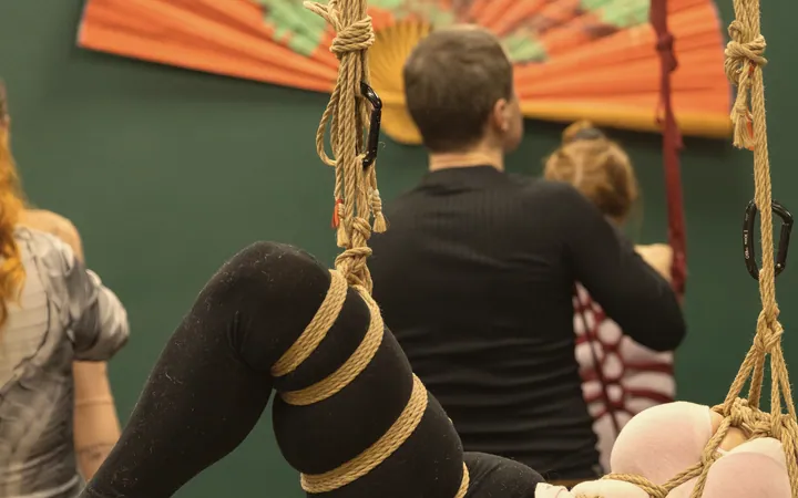 Legs wrapped in jute during a partial suspension in a group class.
